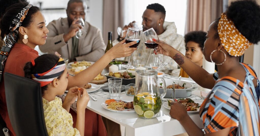 Black family toasting at the dinner table