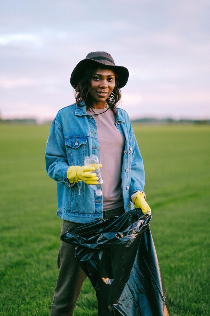 Black woman volunteer picking up trash