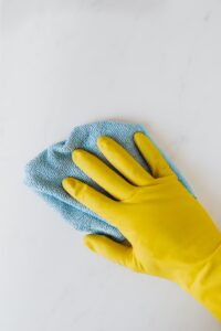 Gloved hand using towel to wipe a surface