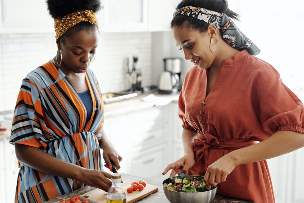 Two Black women preparing a meal together