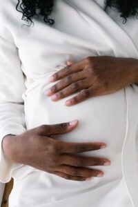 Black woman holding her pregnant belly