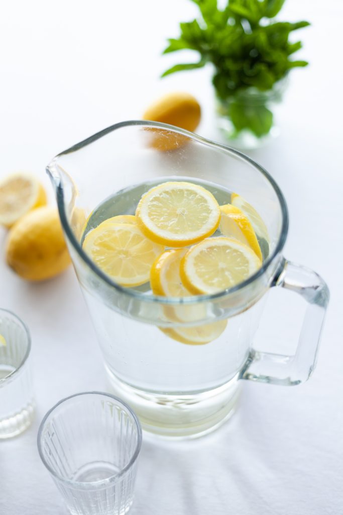 A pitcher of water with lemon slices floating at the top
