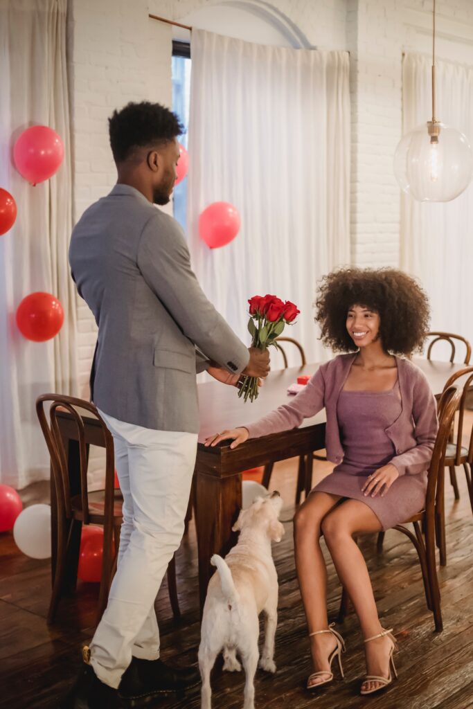 Black man presenting a bouquet of flowers to a Black woman