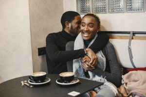 Open relationCheating Black man with his arms around a smiling Black woman