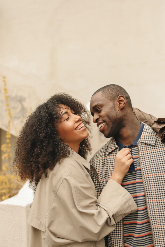 Black couple smiling as they embrace each other