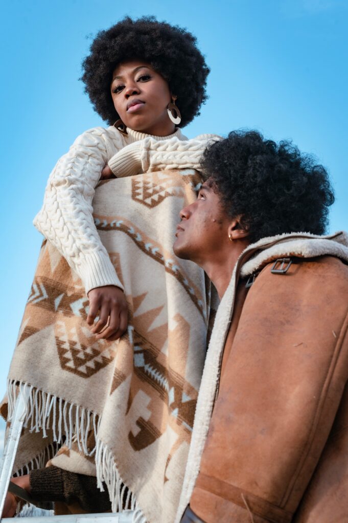 Black man looking up at a Black woman with an afro