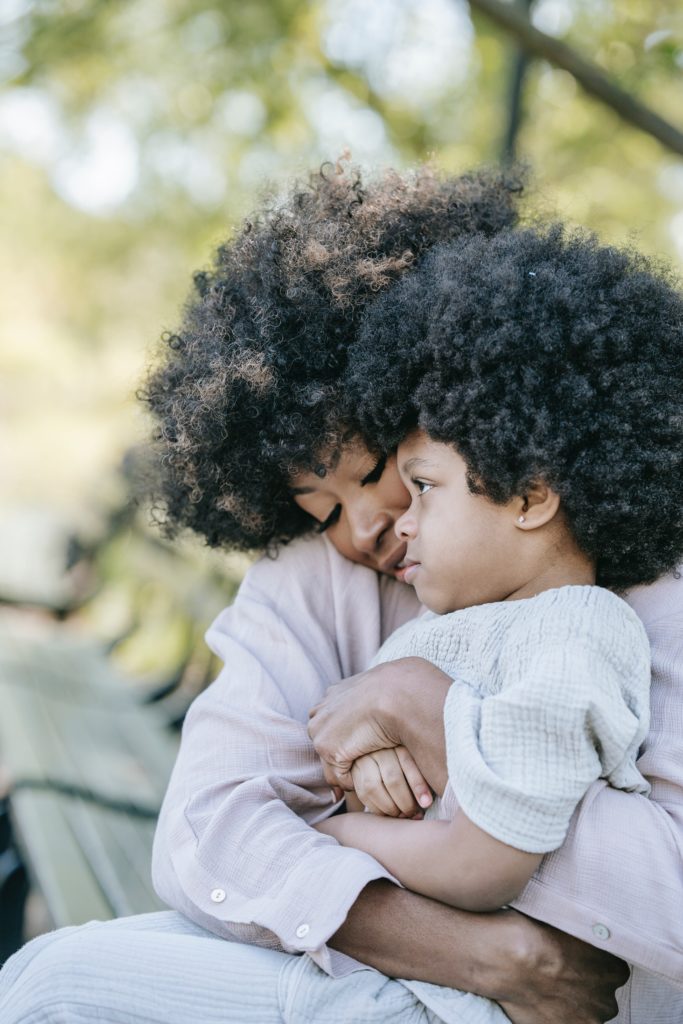 Black mother embracing her toddler