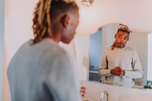 Black man looking at himself in the mirror