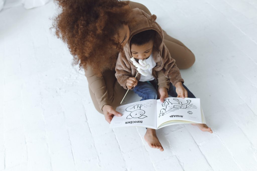 Black mother reading to her infant
