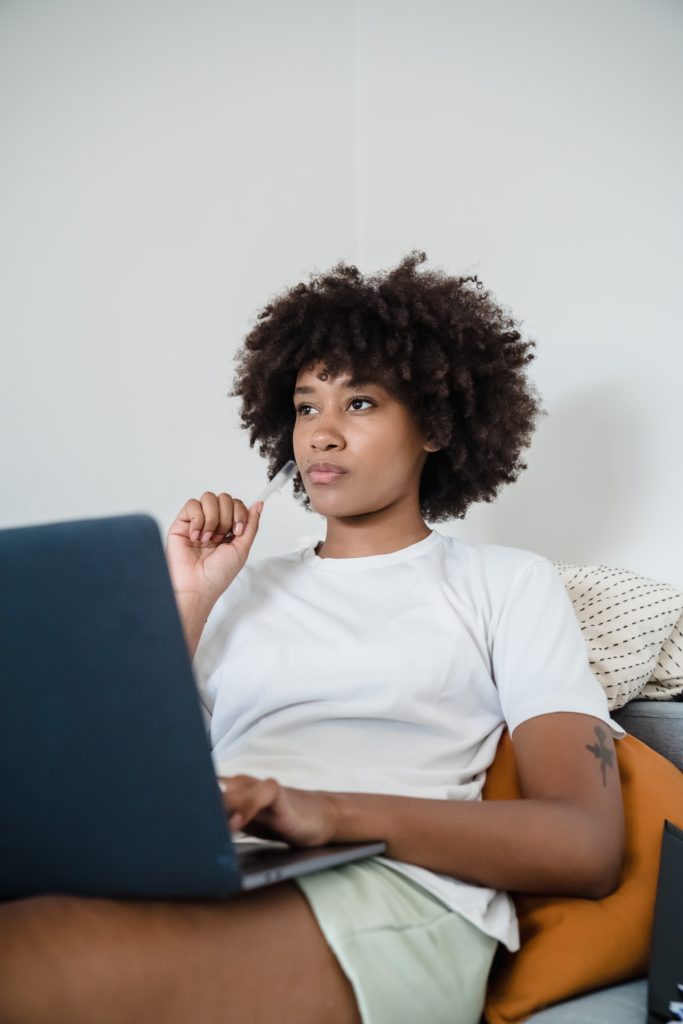 Black woman thinking in front of her laptop