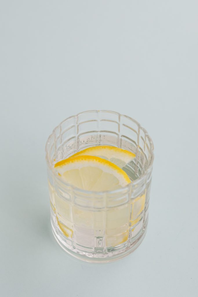 A glass of water with two slices of lemon inside