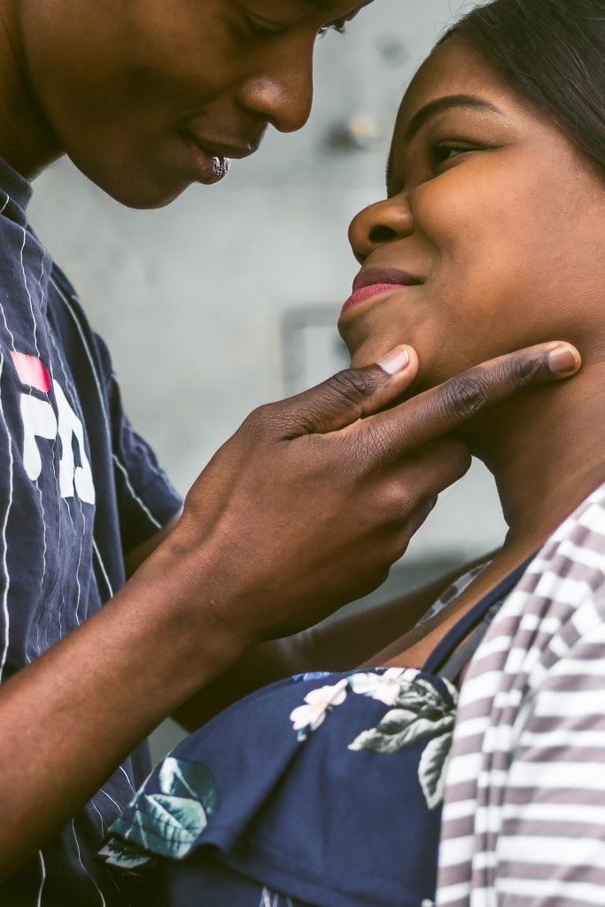 Black man leaning in to kiss a Black woman