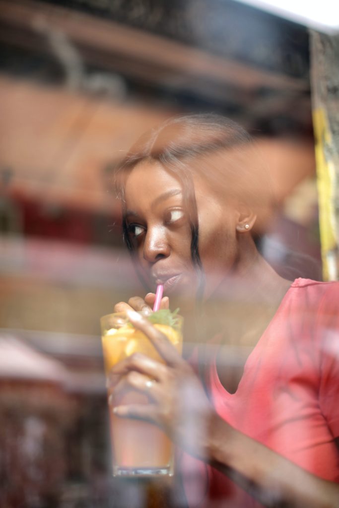 Black woman sipping a drink
