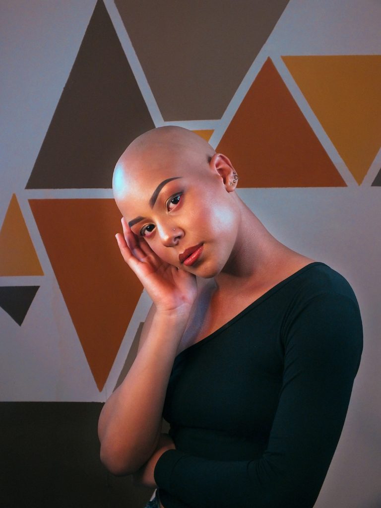 Bald Black woman looking into the camera