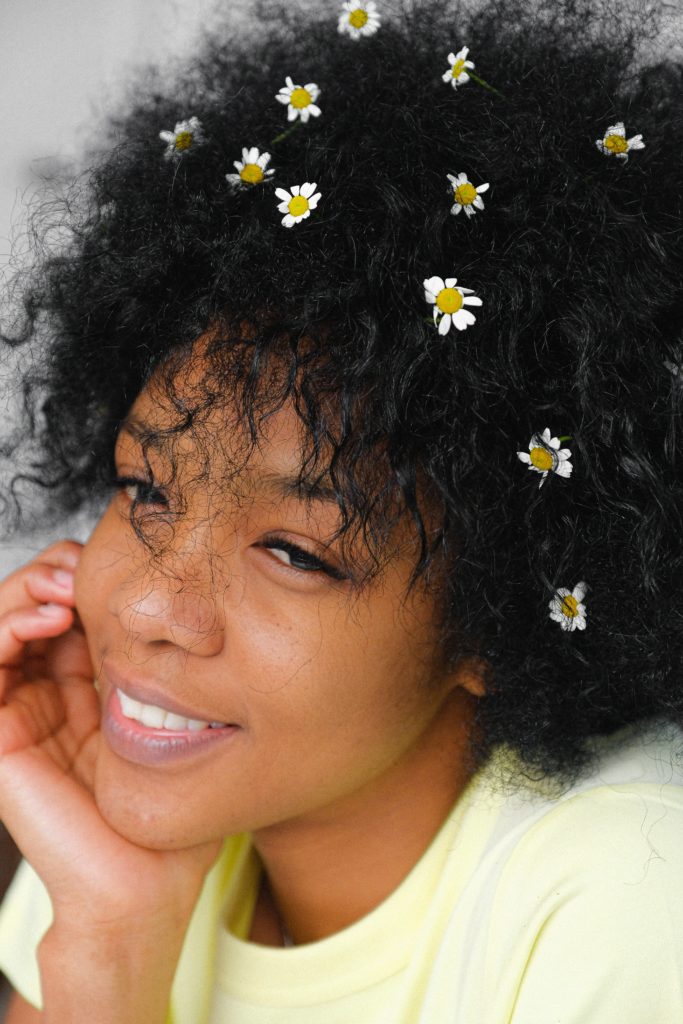 Smiling Black woman with flowers in her hair