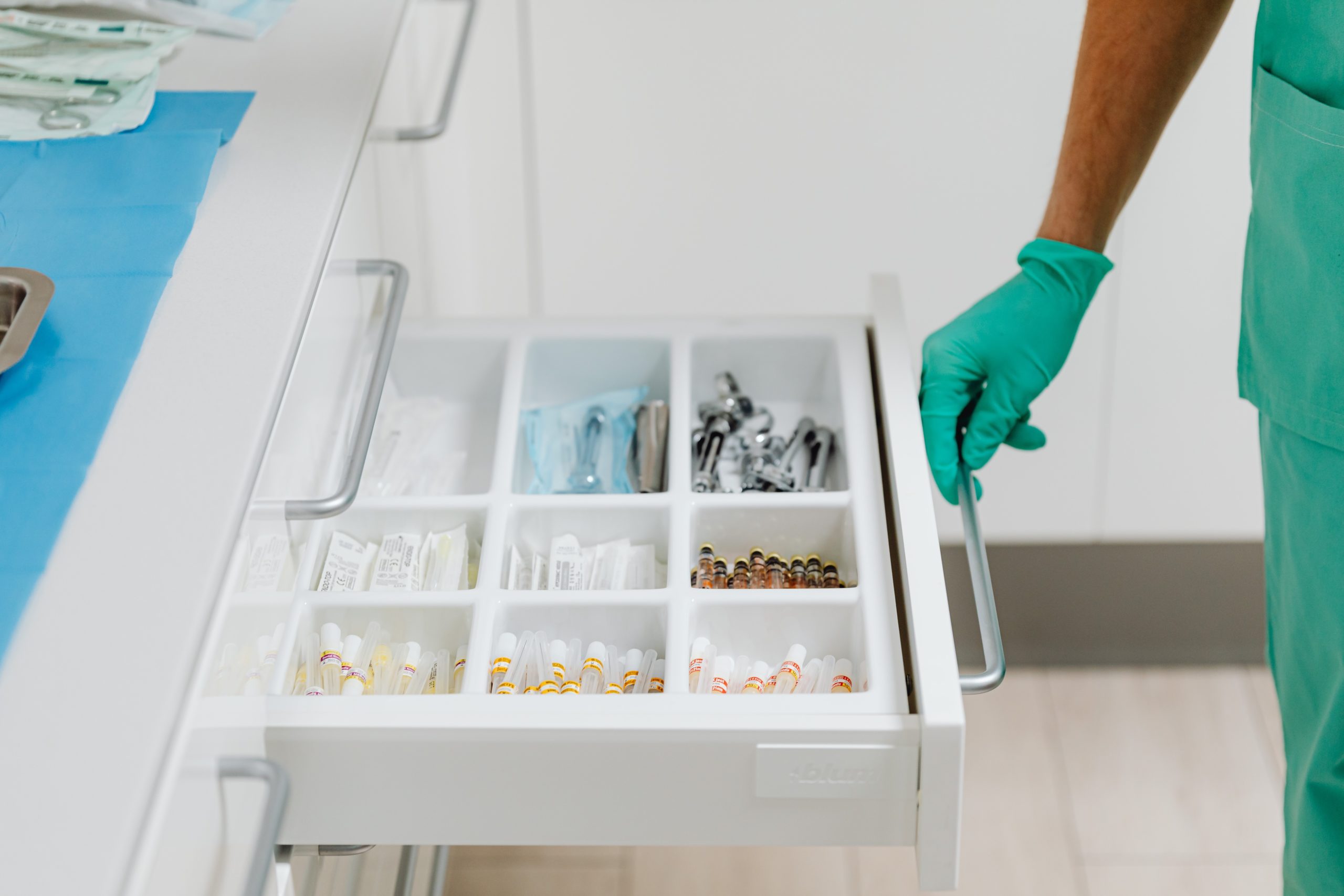 Medical professional opening a hospital drawer to reveal several medical instruments