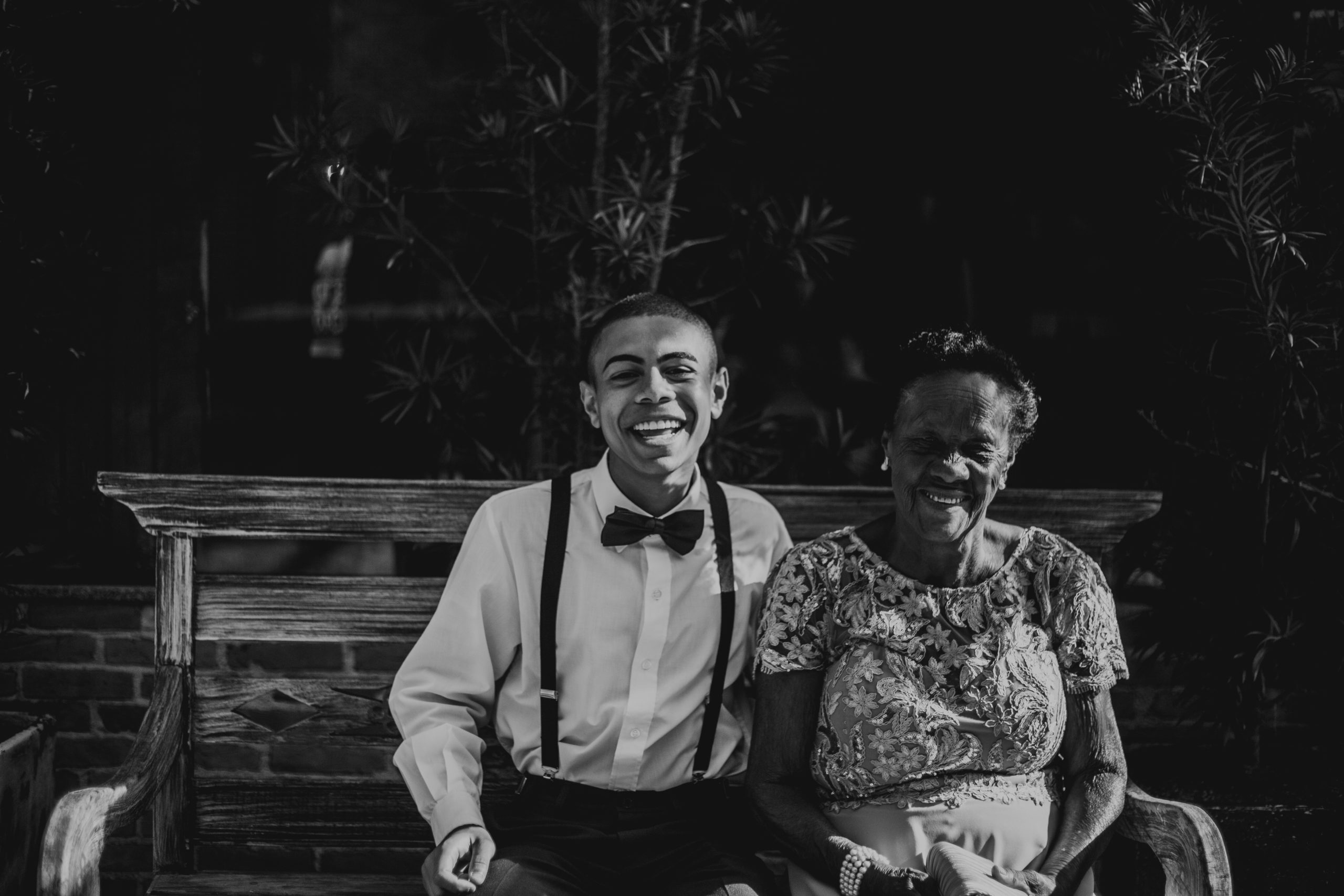 A Black man sitting on a bench with his grandmother