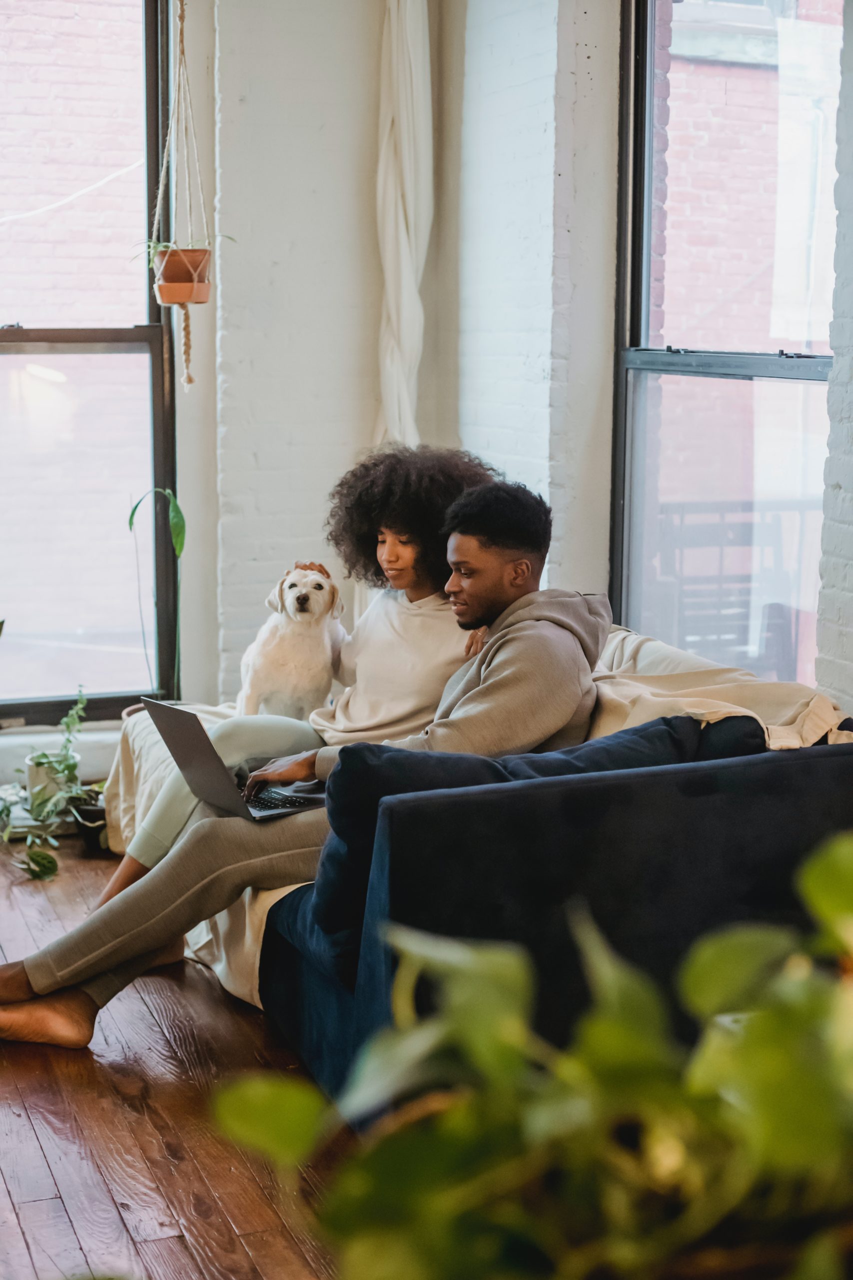 A young couple sharing a laptop while sitting on a couch