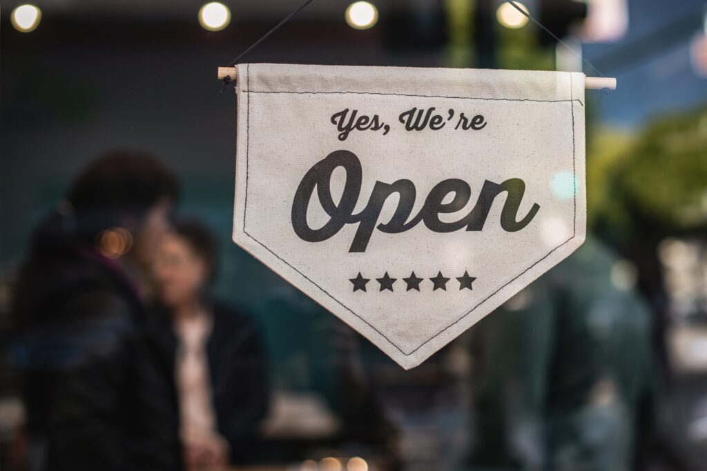 An open sign hanging in the window of a small business