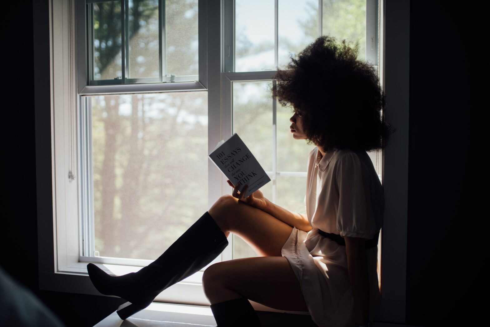 Women reading book in window seal