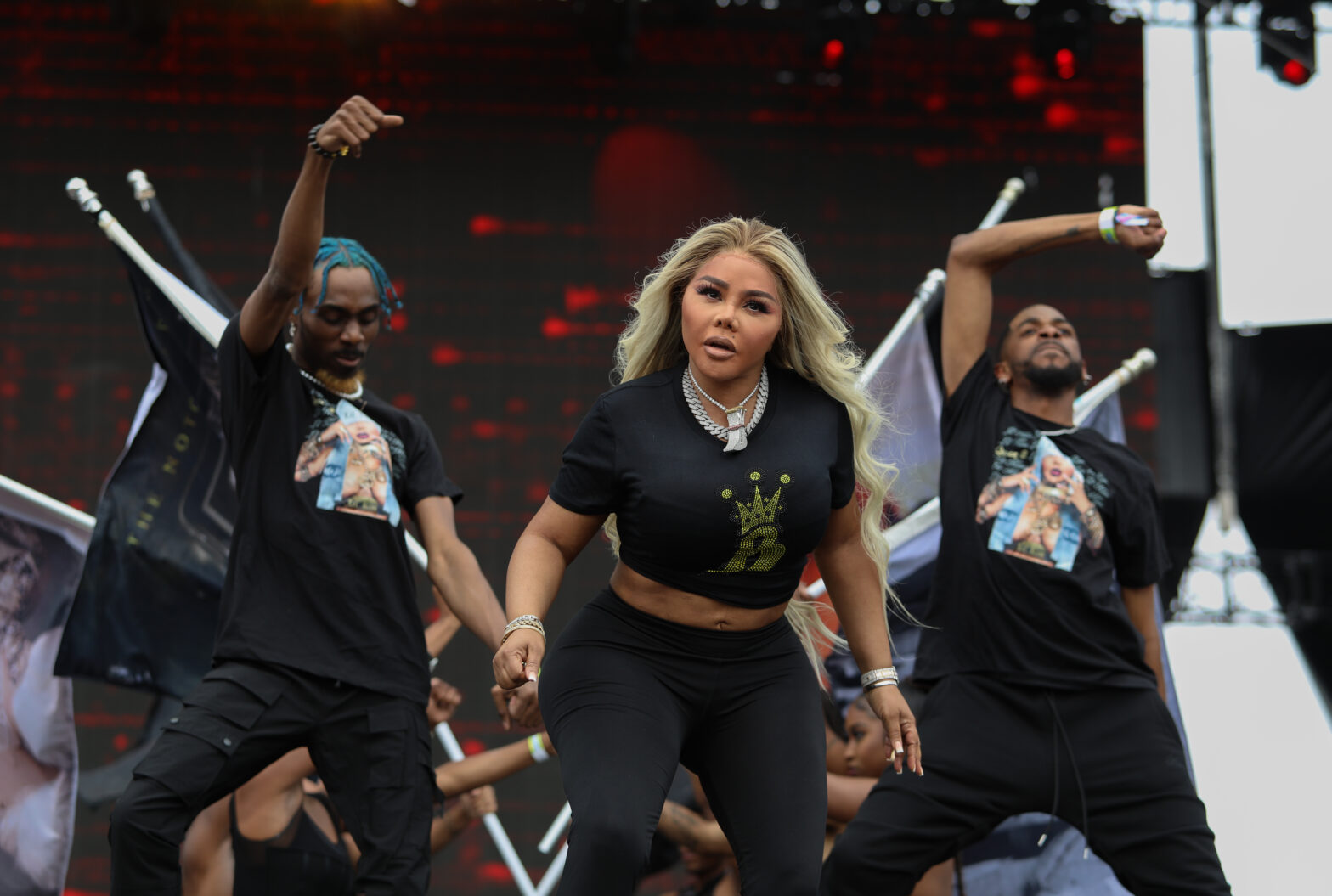 lil' kim performing on stage with two dancers behind her