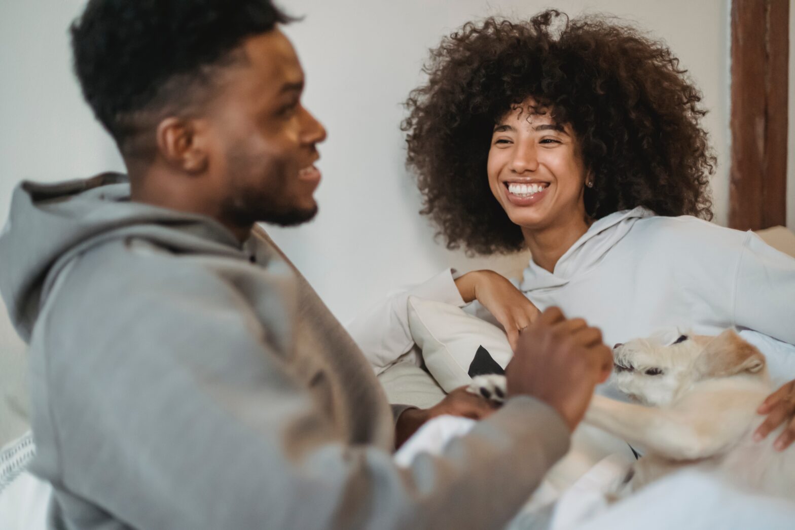 black couple playing would you rather questions on the couch laughing.