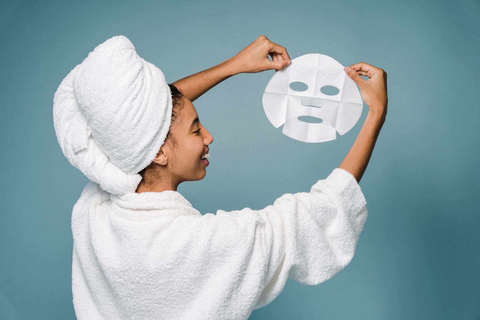 black-woman-applying-sheet-mask-for-treatment