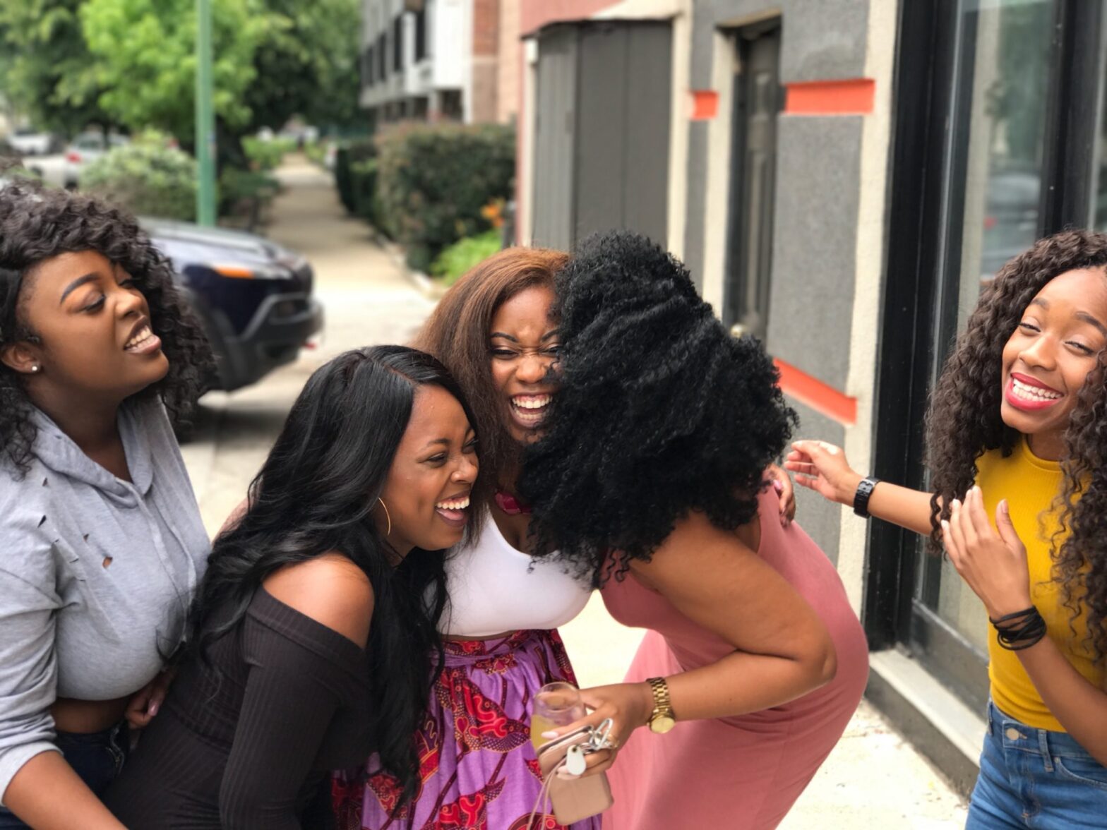 What does it mean to have a ride or die in your life? Find out all the traits and see who that extra special someone is in your life. Pictured: 4 black girls laughing and sharing a joke together on the street.