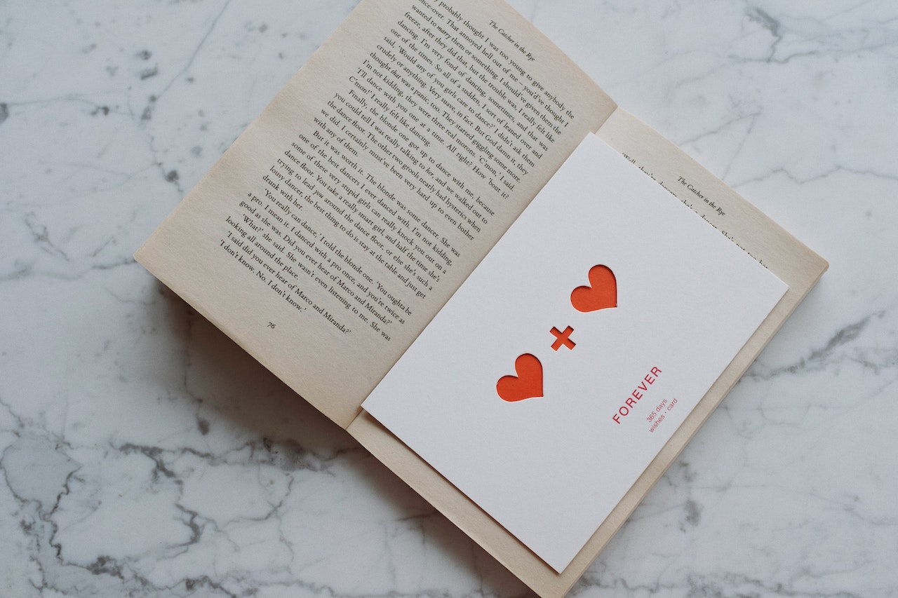 Here are 100 of the best ways to say I love you that will make their heart race. Pictured: An open book on a marble table with a love note inside of it.