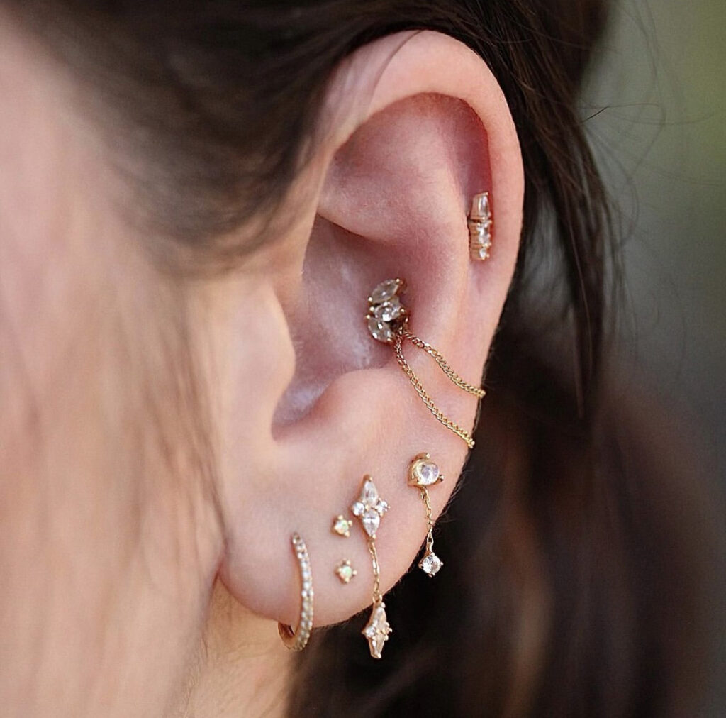 Where ear piercings rank in most painful piercings. pictured: ear with multiple piercings