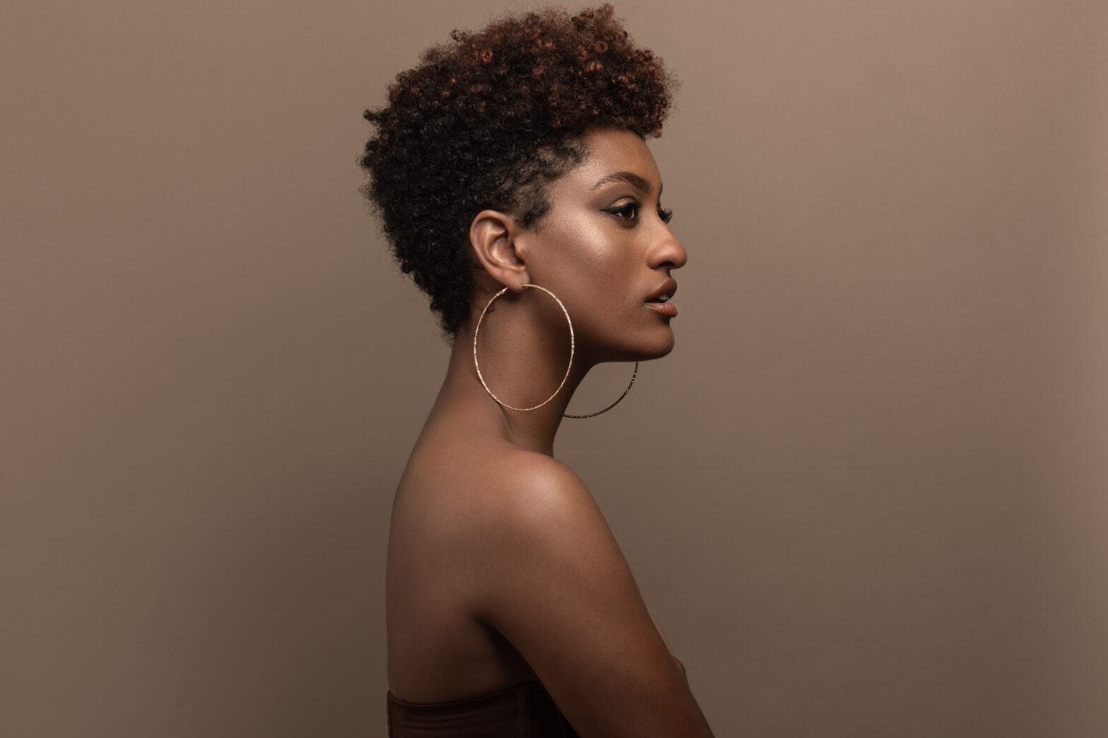 A side profile of a nude Black woman with an afro