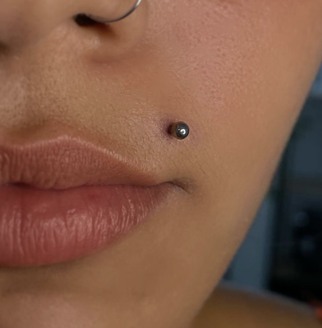 A comprehensive life of the most painful piercings you can get. pictured: girl with a Monroe piercing