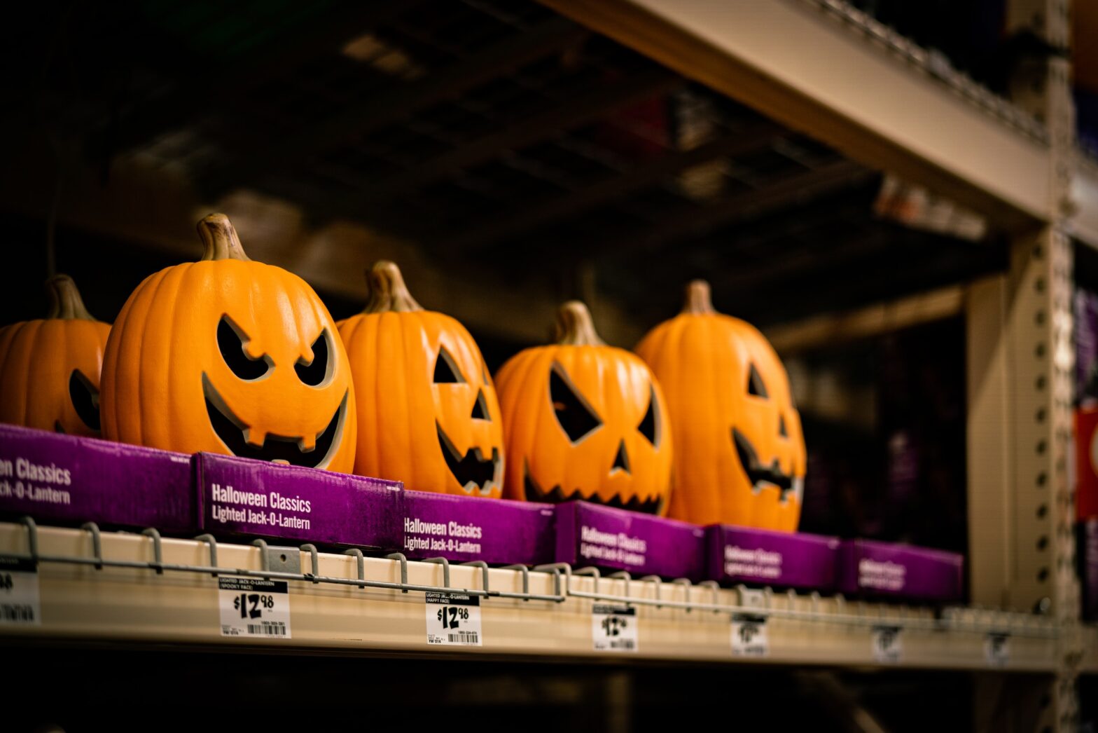 A row of pumpkins on display in an aisle