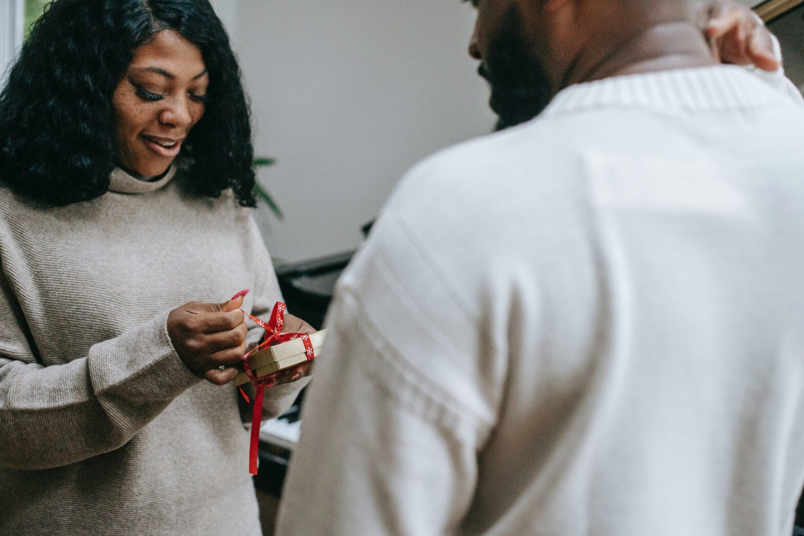 Black-couple-in-sweaters-congratulating-each-other-on-christmas