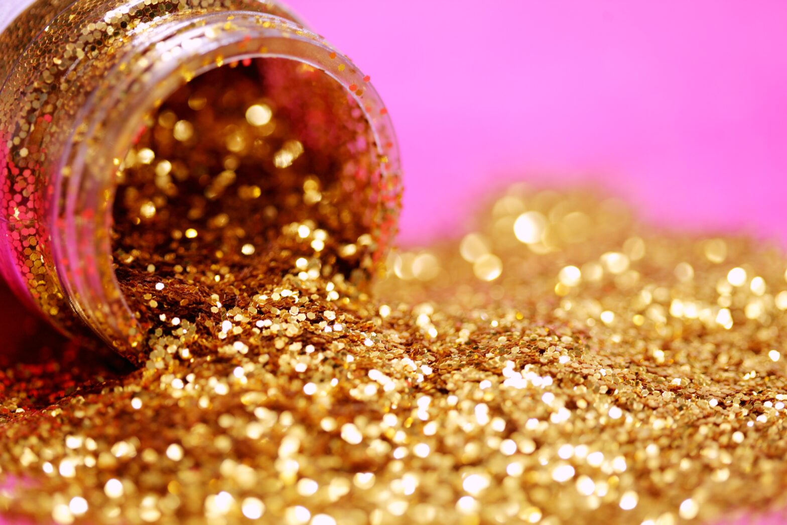 pink background gold glitter and bottle