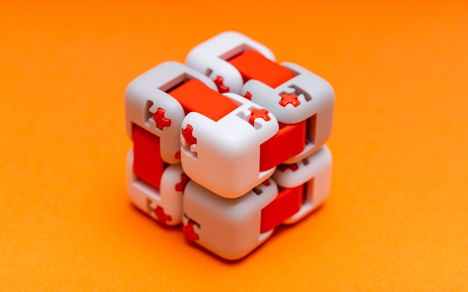 gray and red fidget cube on orange background