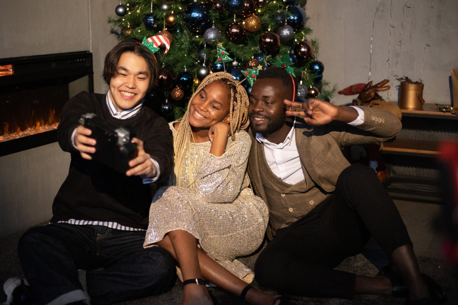 A group of friends taking a photo by a Christmas tree