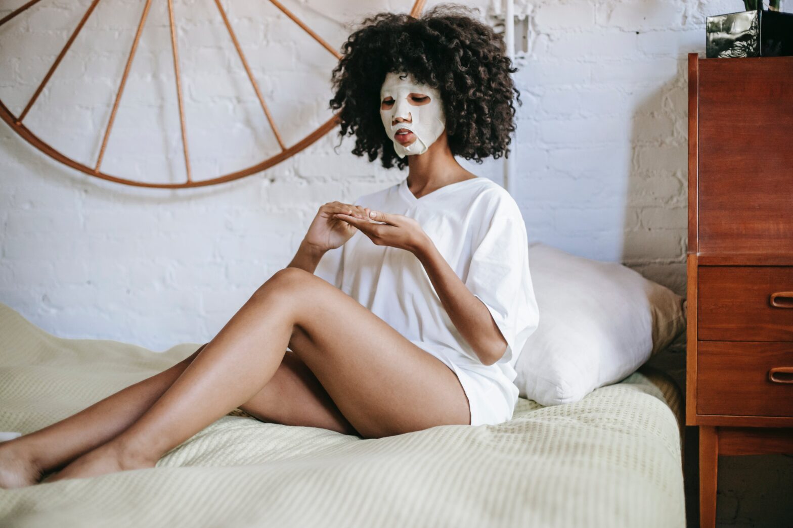 young-woman-with-facial-mask-relaxing-on-bed
