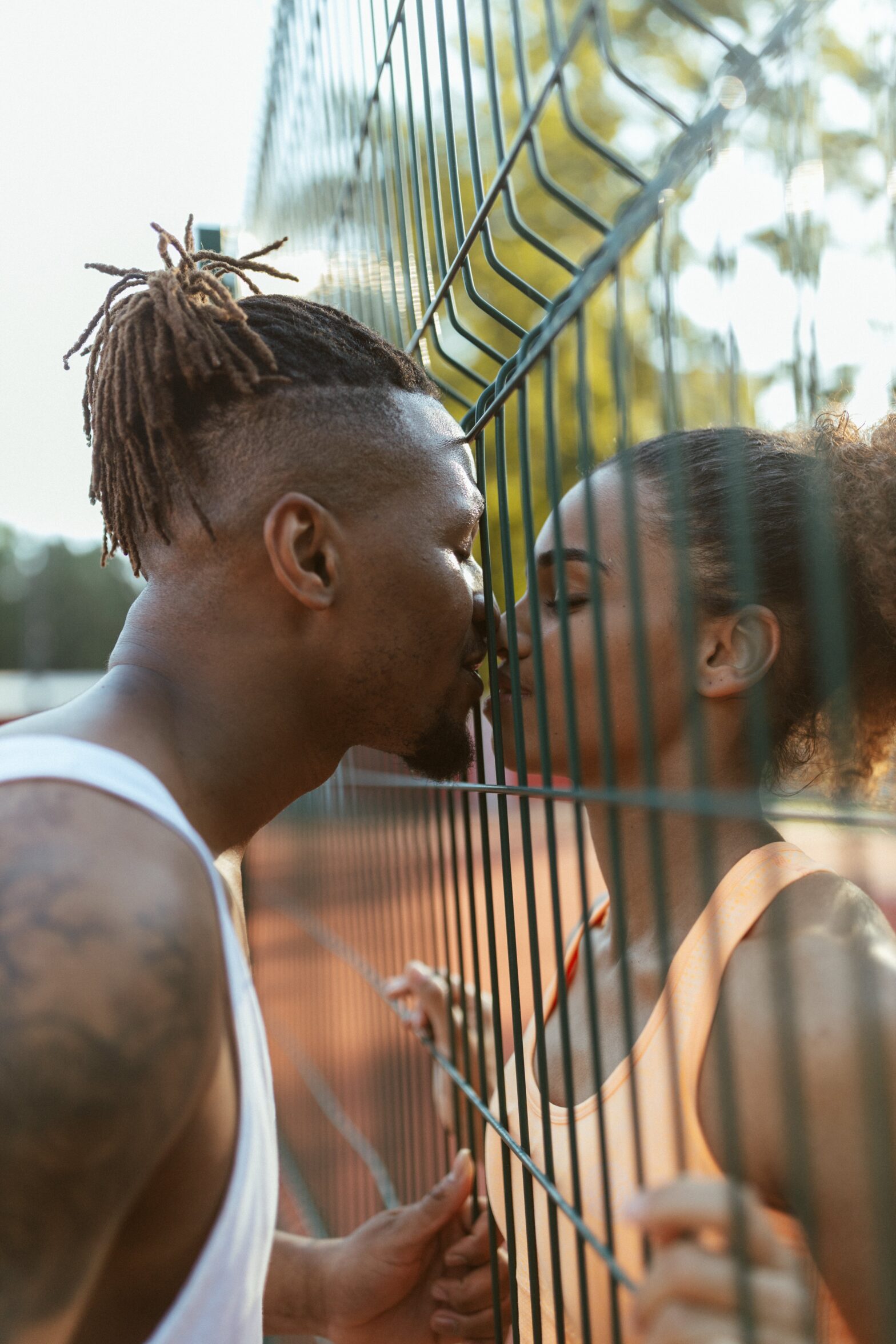 capricorn and aries compatibility. pictured: black lovers kissing from a fence