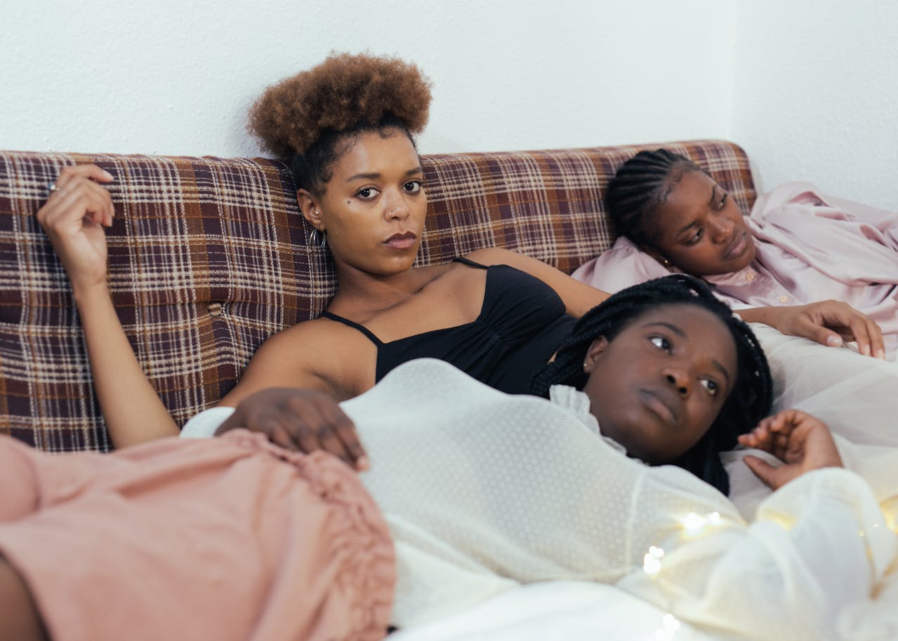 Why having a third place is so crucial for Black women. Pictured: three women lying on a couch.