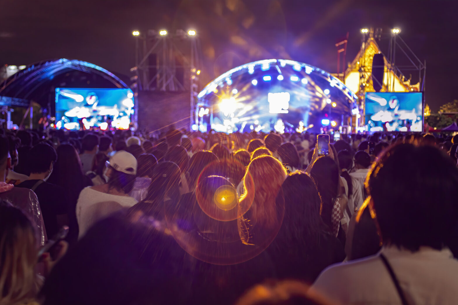 People at Music Festival with Illuminated Lights At Night Background