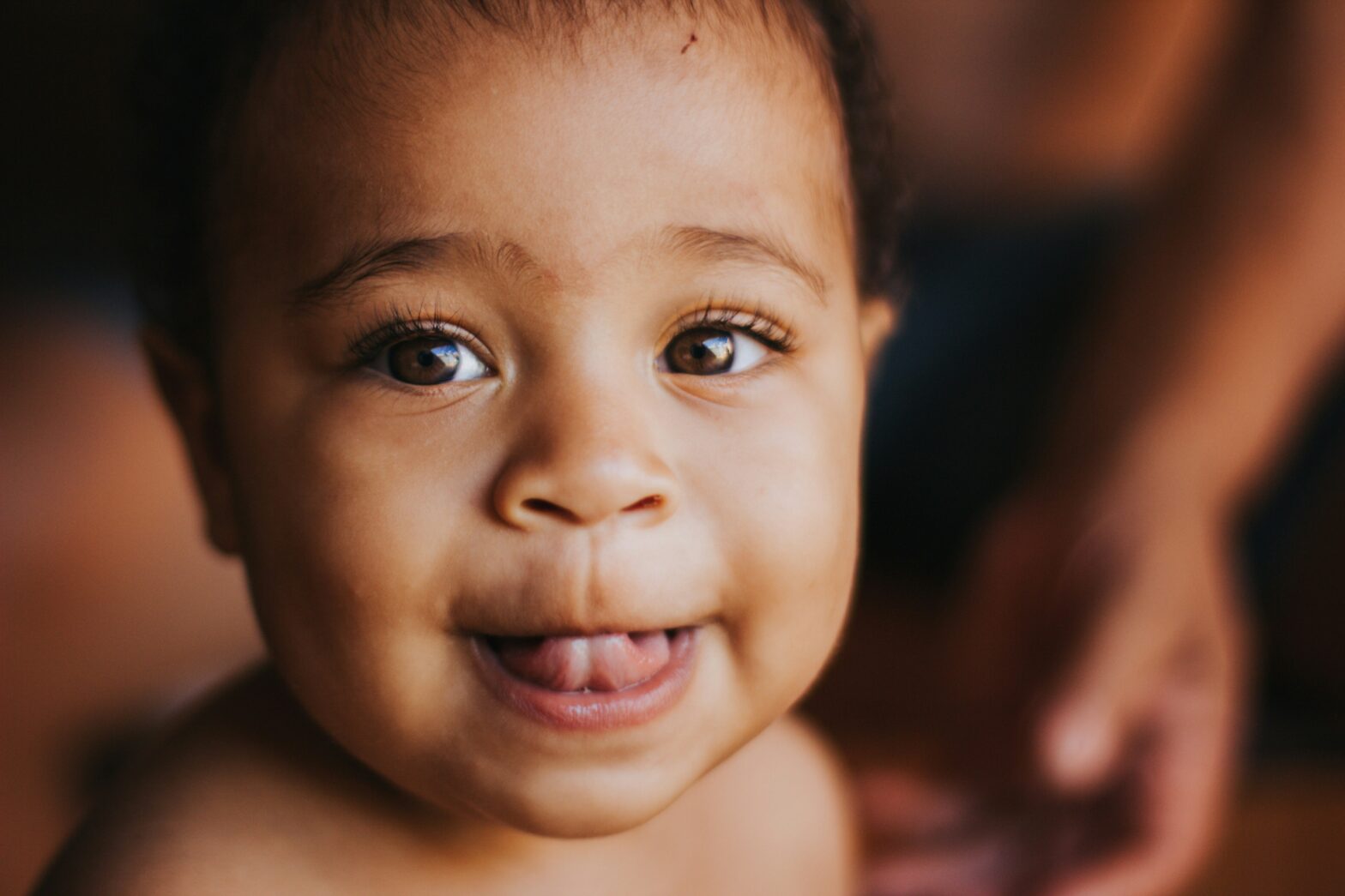 Learn more about how your bundle of joy will express happiness with their adorable laugh. Pictured: a Black baby with an expression of happiness