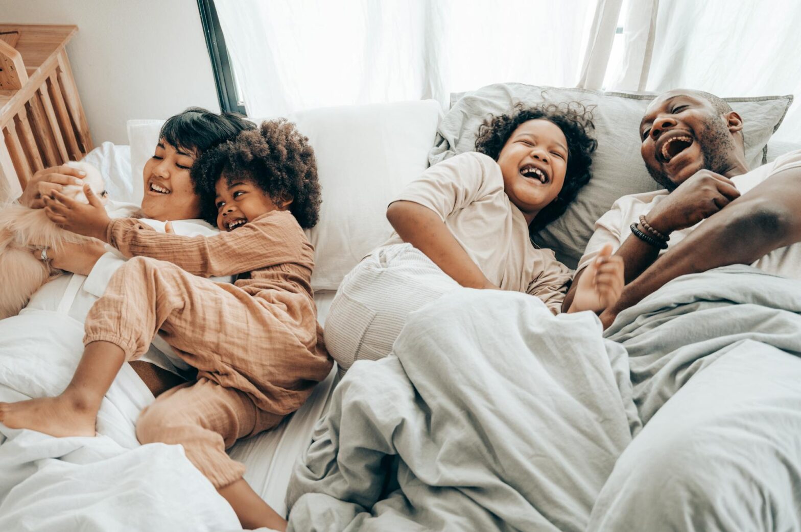 A happy multiracial family having fun together in bed