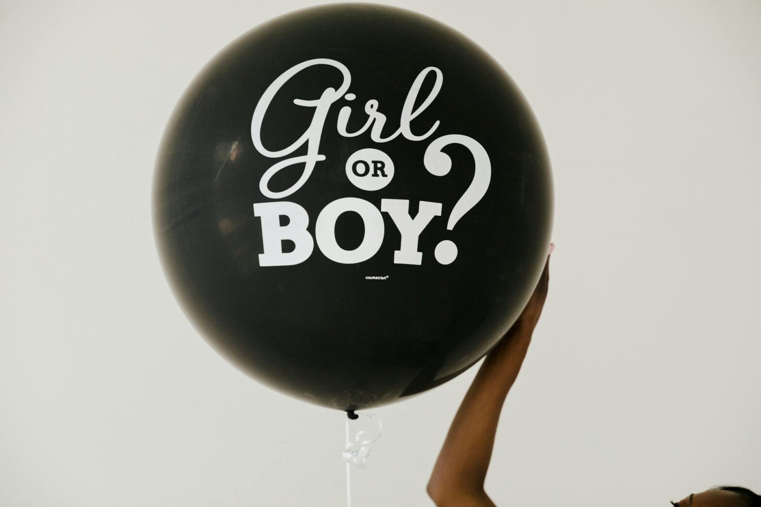 Photo of a black balloon floating that says girl or boy?