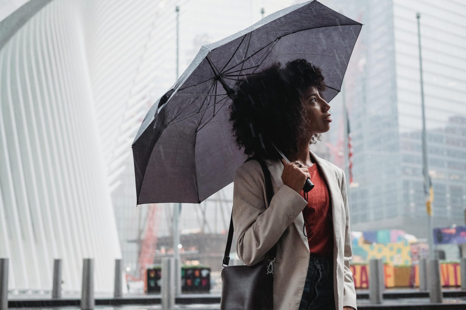 Black-woman-in-white-coat-holding-umbrella