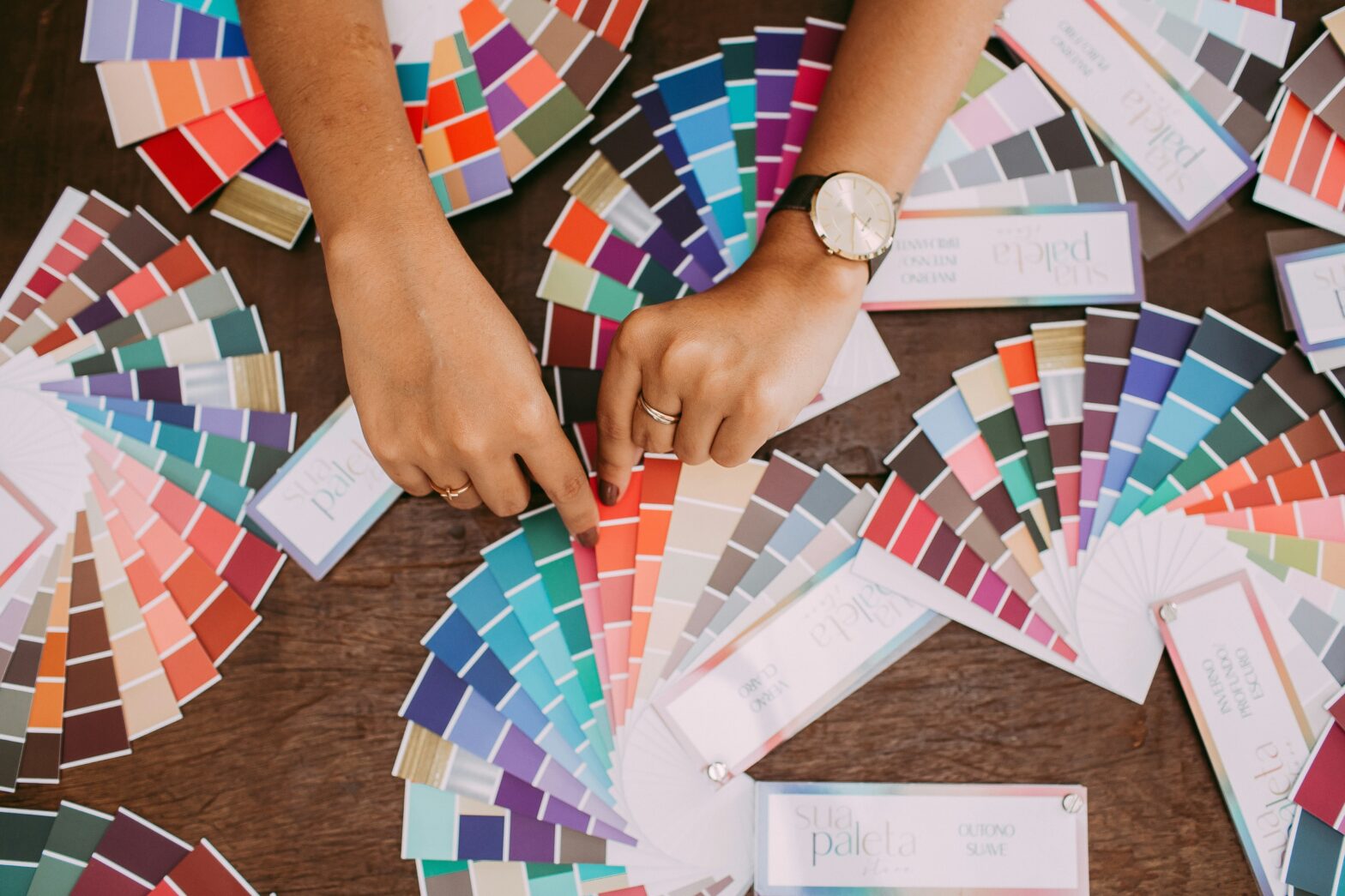 Hands choosing swatches from Pantone books