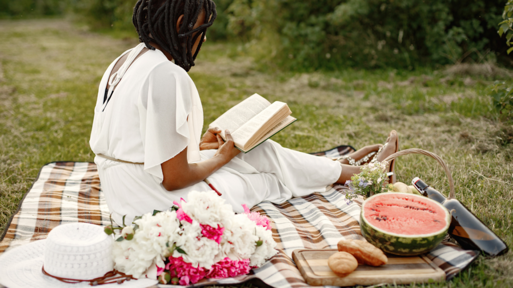 Black woman reading a book outside