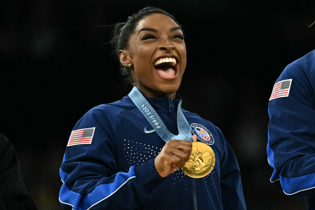 US' Simone Biles poses with the gold medal during the podium ceremony for the artistic gymnastics women's team final during the Paris 2024 Olympic Games at the Bercy Arena in Paris, on July 30, 2024.