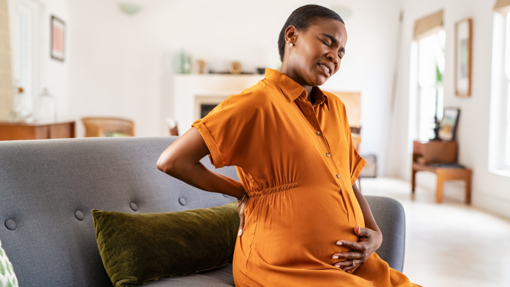 Pregnant Woman Having Backache on the Sofa⁠