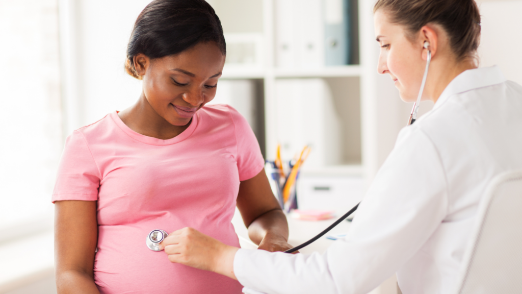 Young black woman getting pregnancy check up